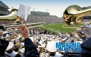 Over the shoulder view of trombone player performing from the stands in Beaver Stadium.