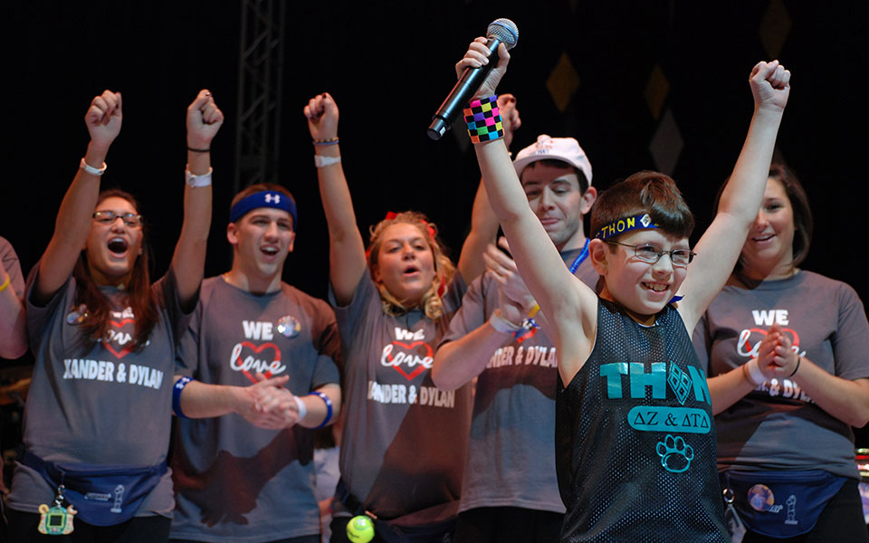 Young kid celebrates with Penn State Students at THON