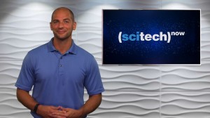 Host Mike Zeman standing next to a monitor displaying SCITECH NOW.