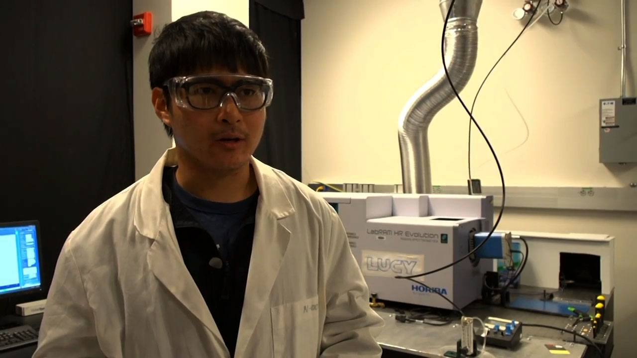 Penn State student standing in front of specrometer