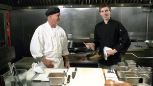 Two chefs cooking in a professional kitchen.