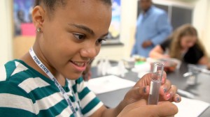Young girl looking at liquid in test tube