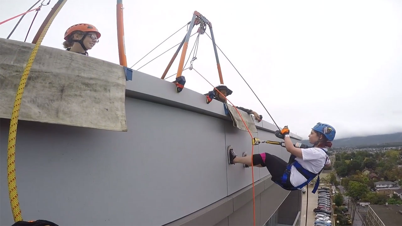 person rappelling of side of building