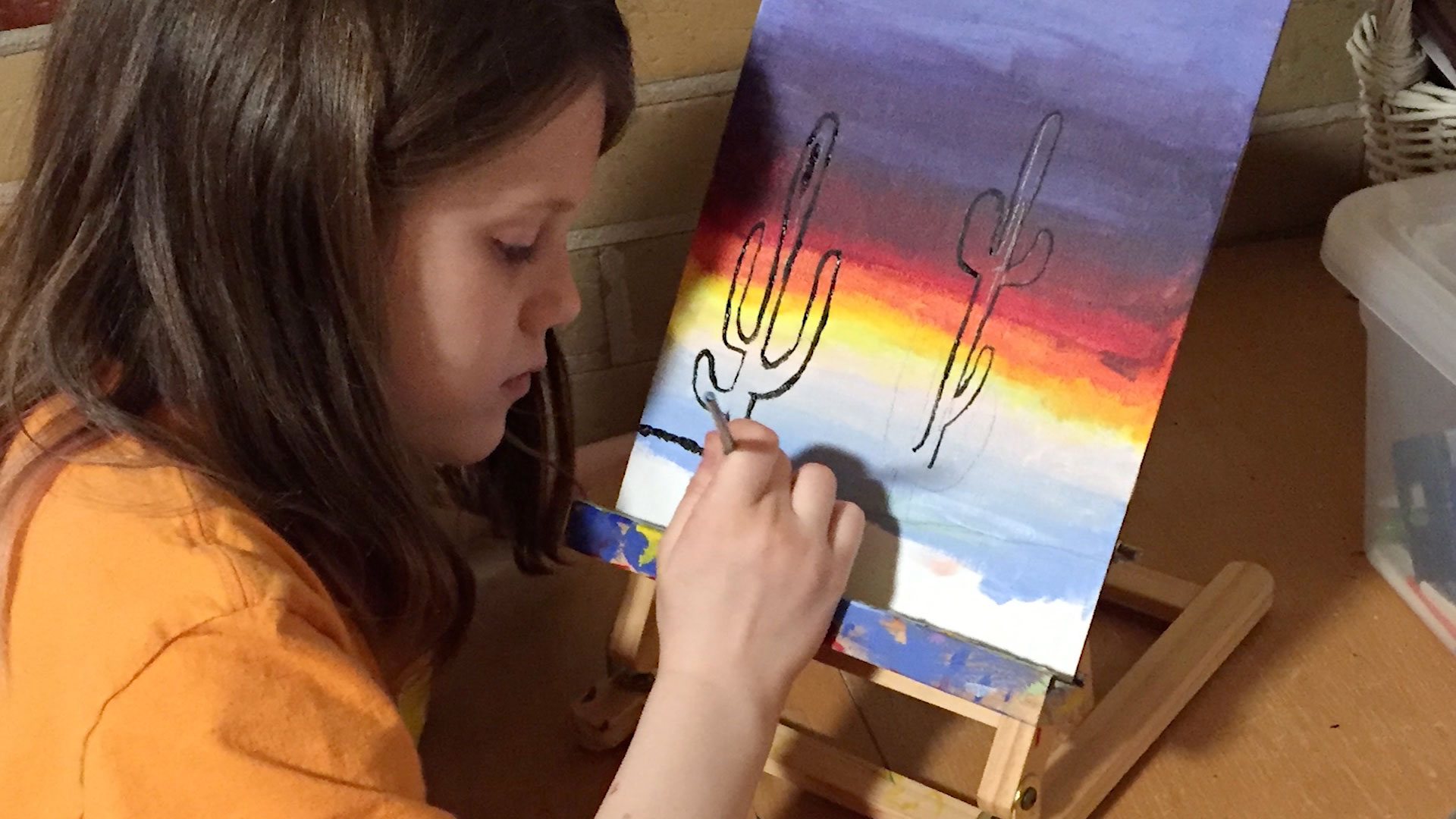 Claire North-Smyers painting on a canvas