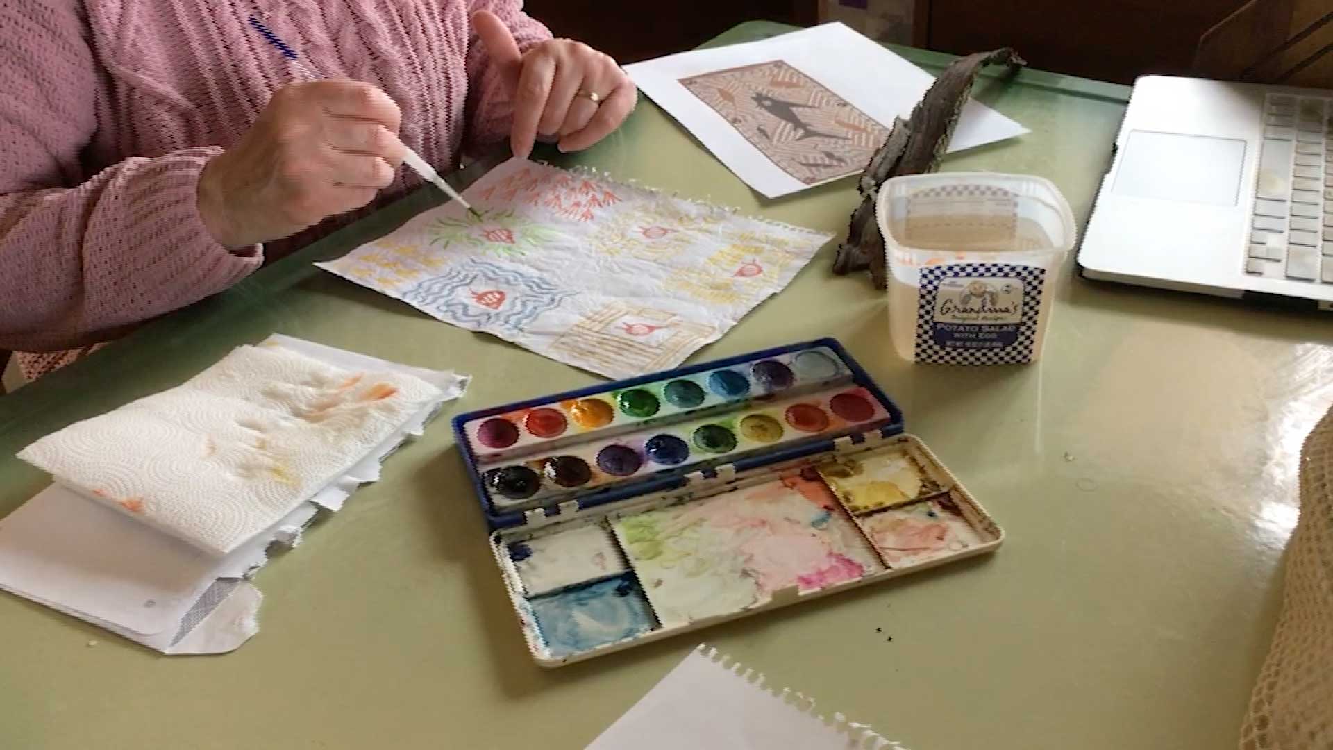 person painting with water colors