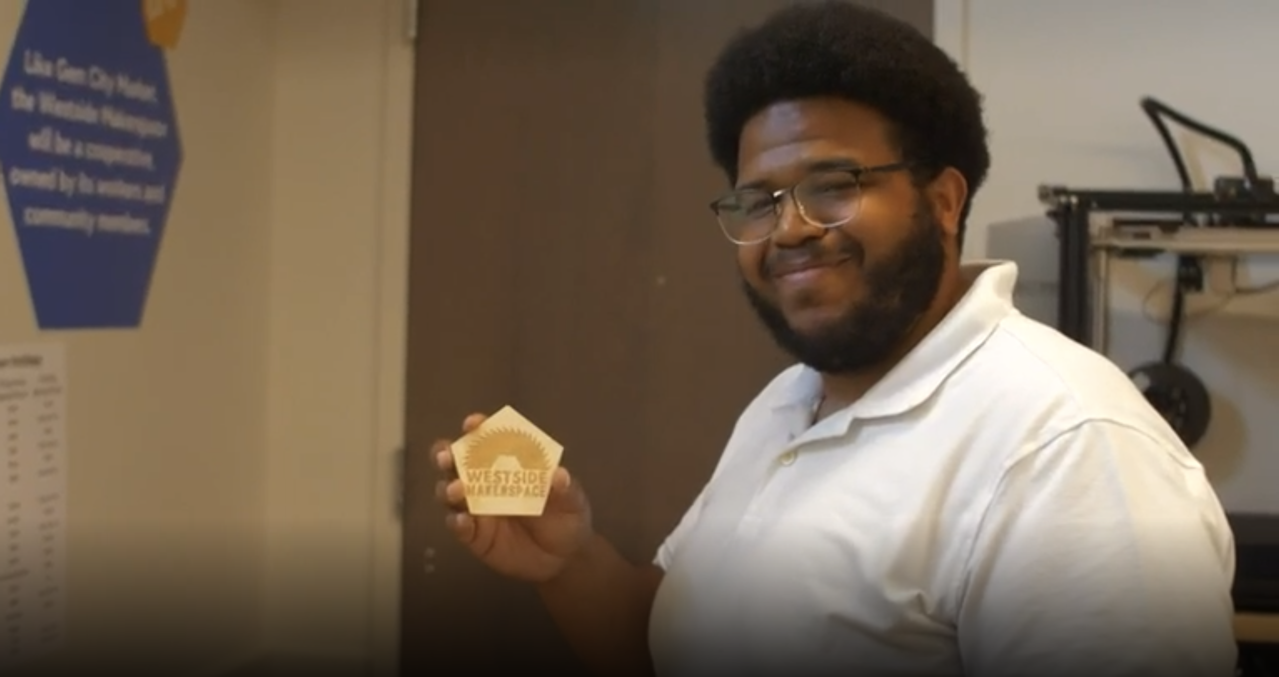 A man holding a wood cut-out from a printer