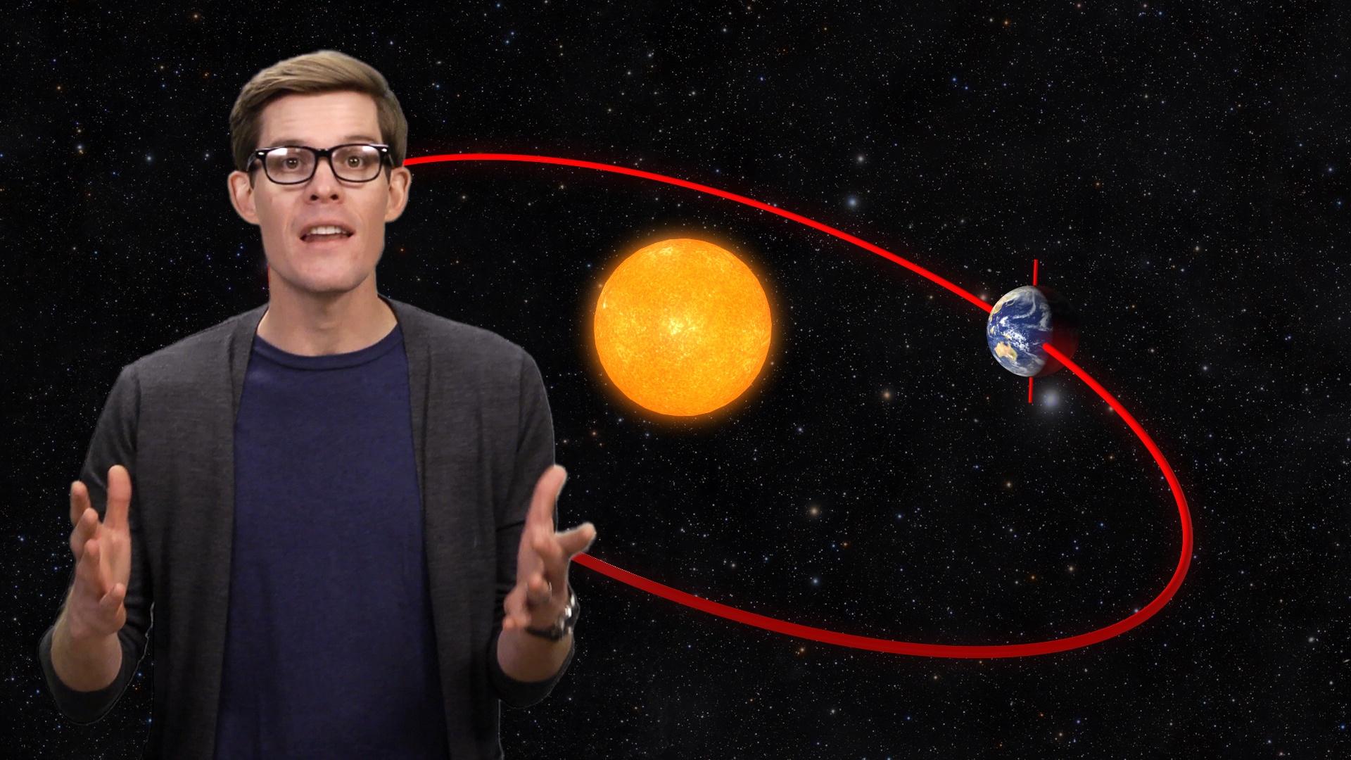 A man standing in front of an image of the Earth rotating around the Sun