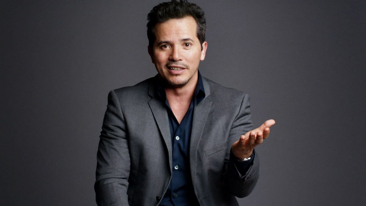 John Leguizamo with his hand up