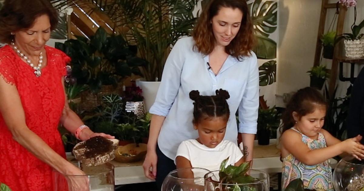 Two women and two girls interact with plants