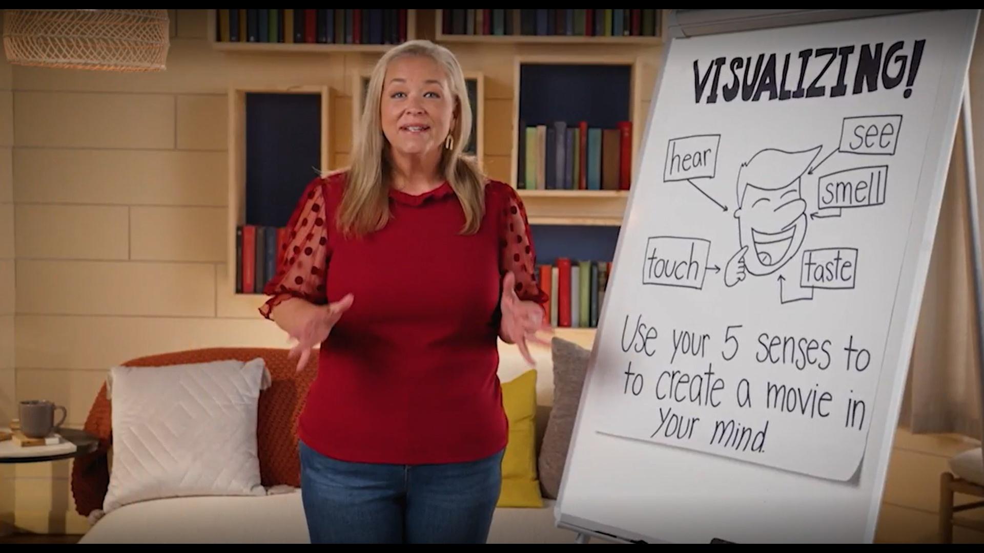 A woman standing next to a drawing about visualizing