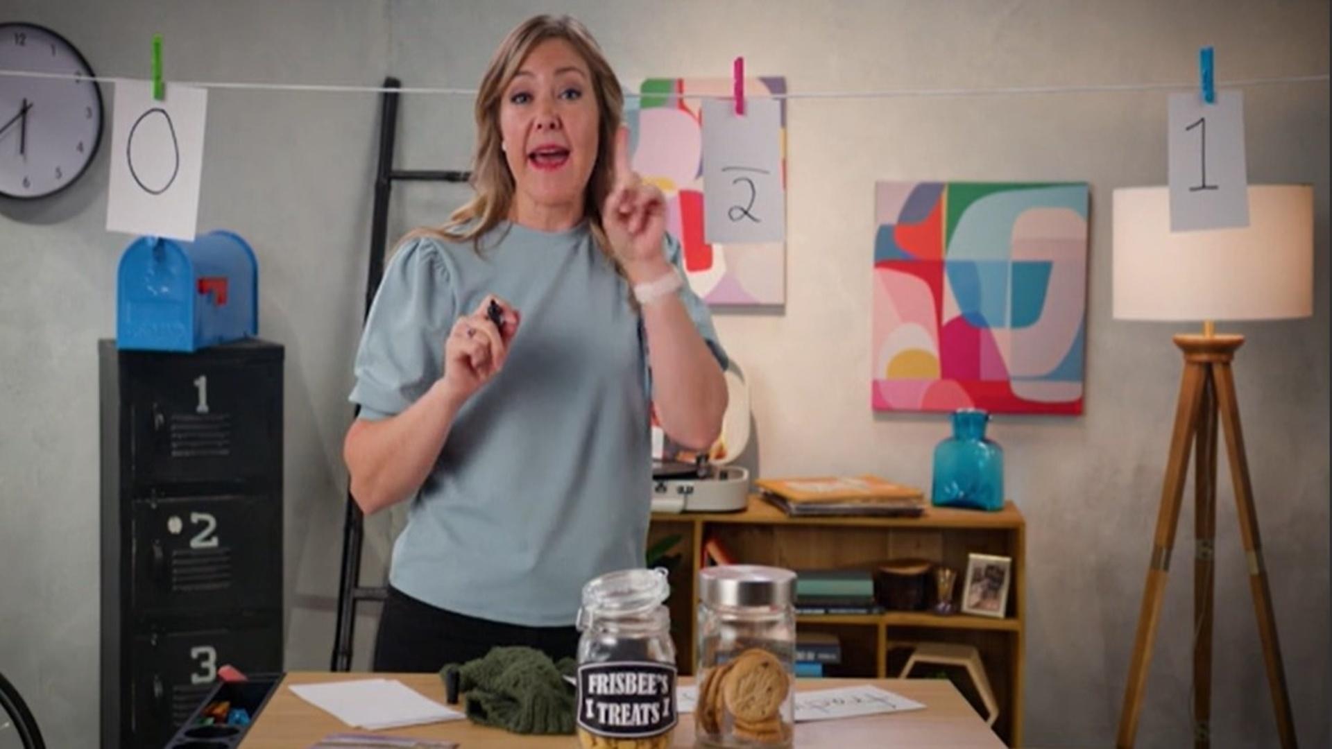 A woman standing in front of a clothes-line number line