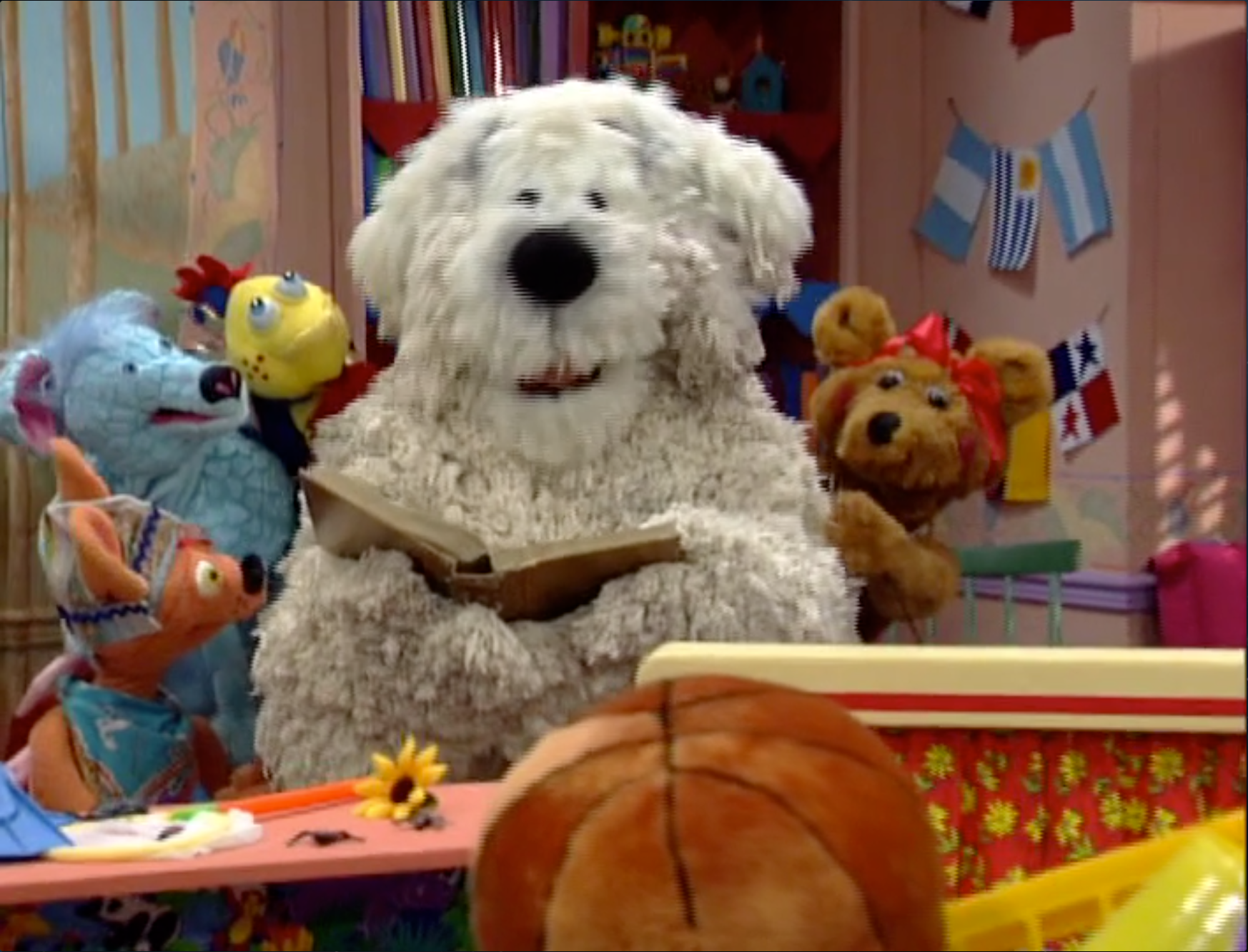 Five large puppets reading a book