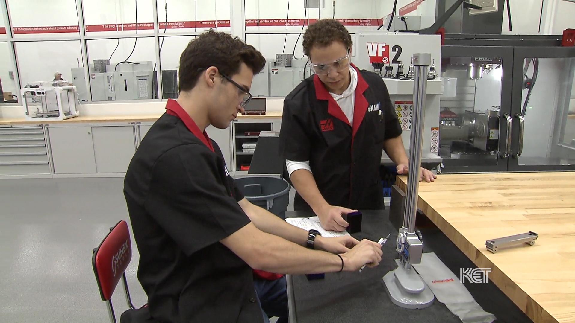 Two men looking at a technical gauge.