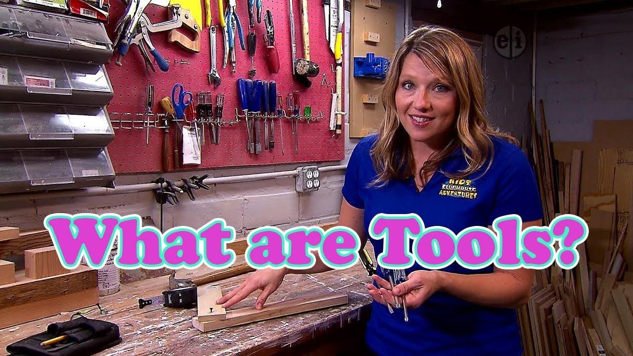 A woman standing at a craft bench with tools on the wall