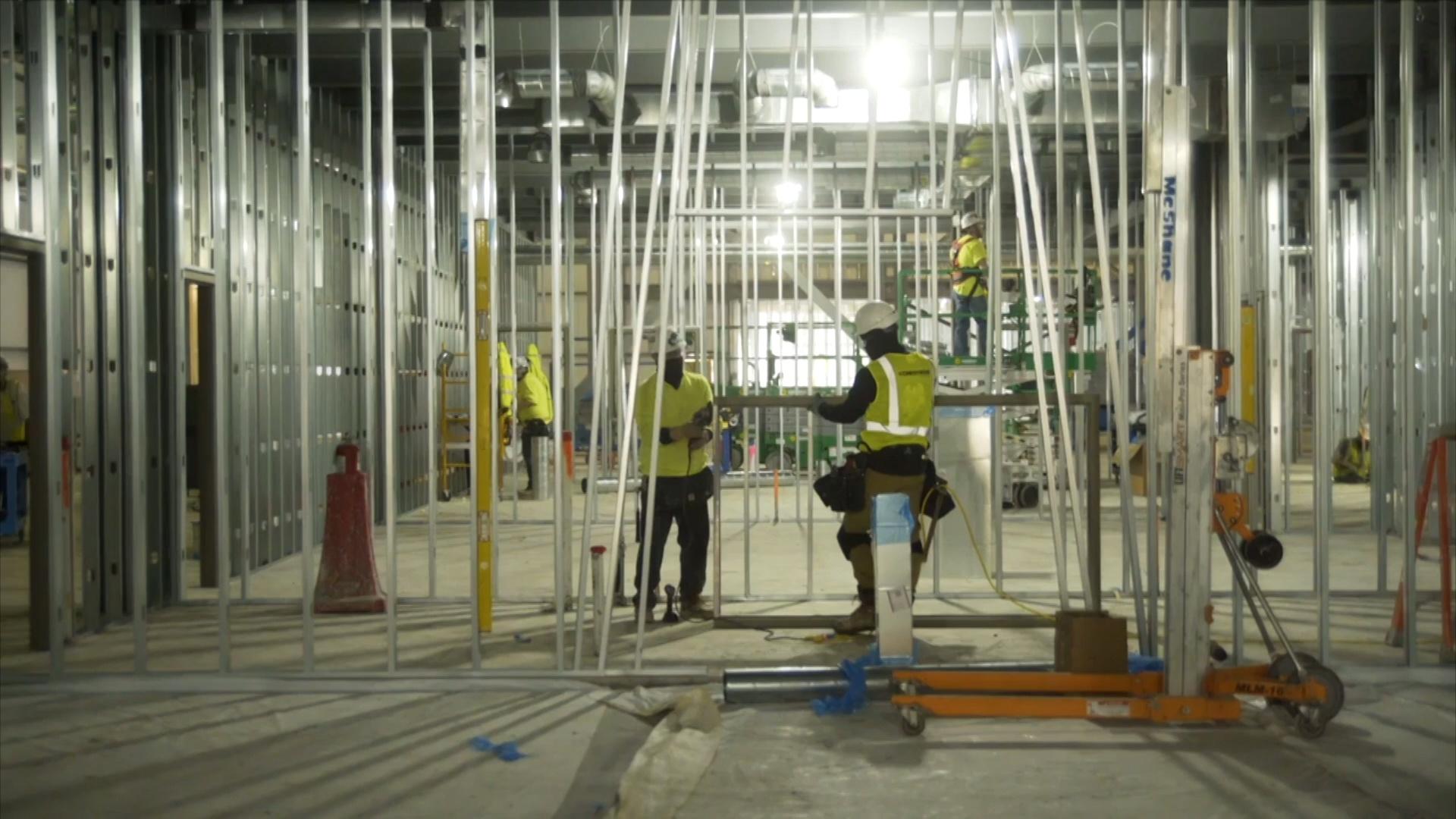 Men working on metal framing in a building