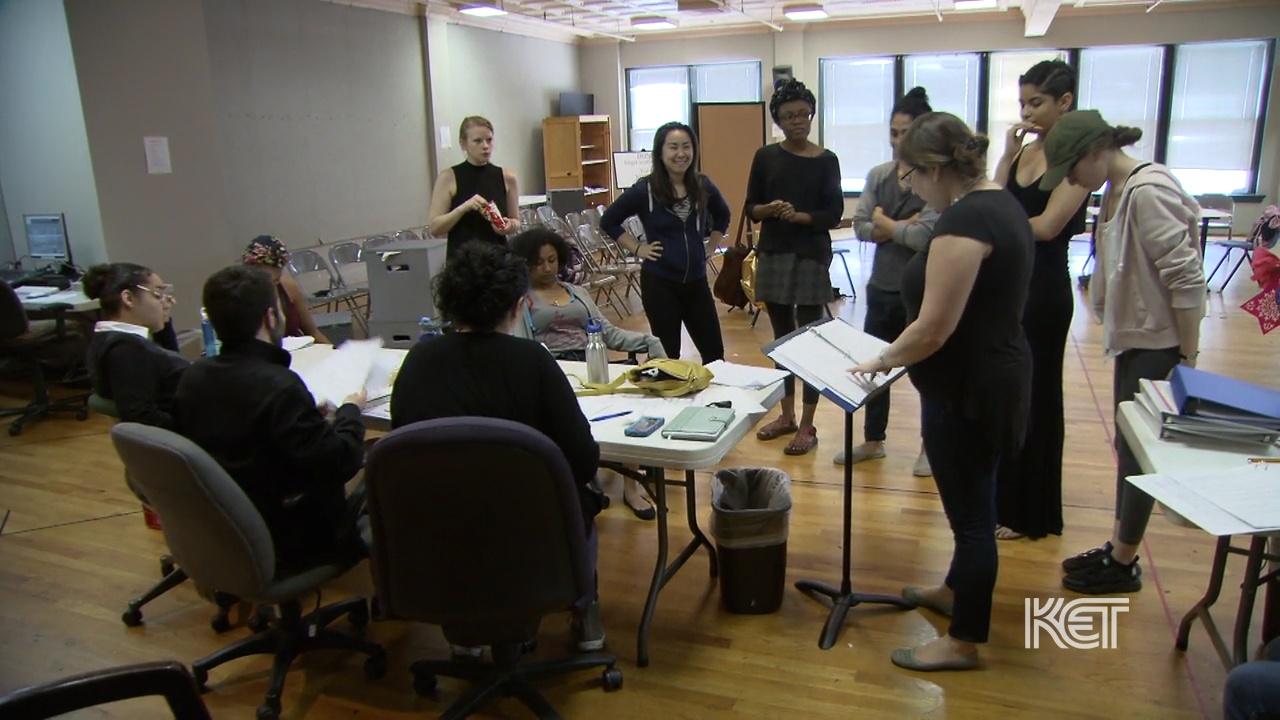 A group of individuals in a room rehearsing