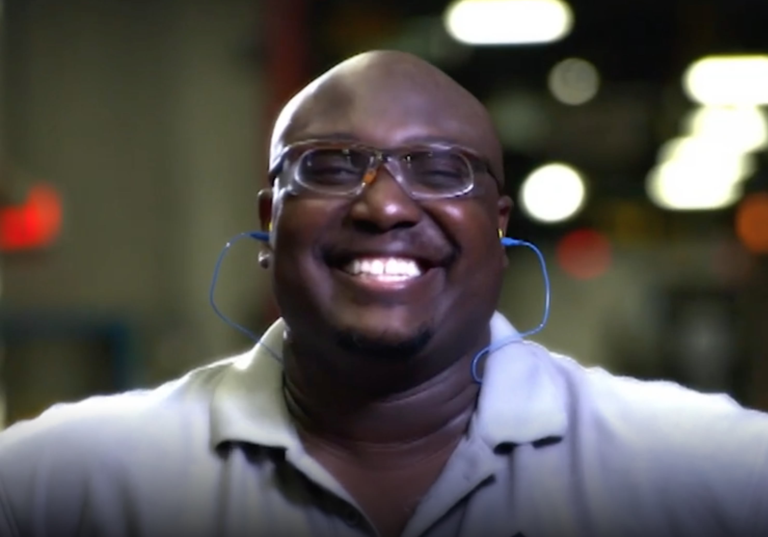 A man smiling with ear plugs in