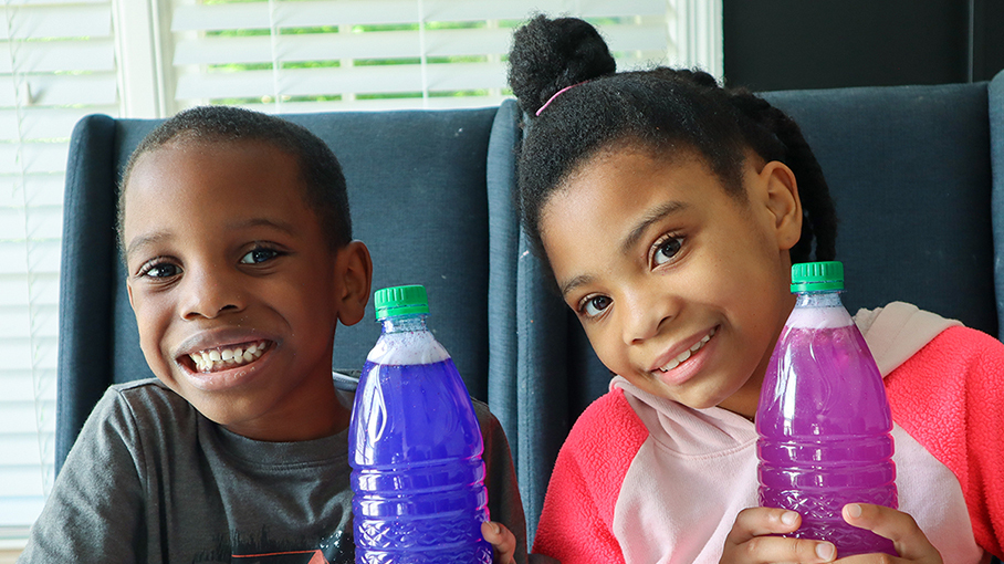 A boy and girl holding glitter jars