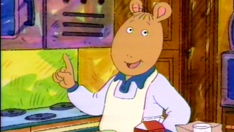 A cartoon character wearing an apron in a kitchen