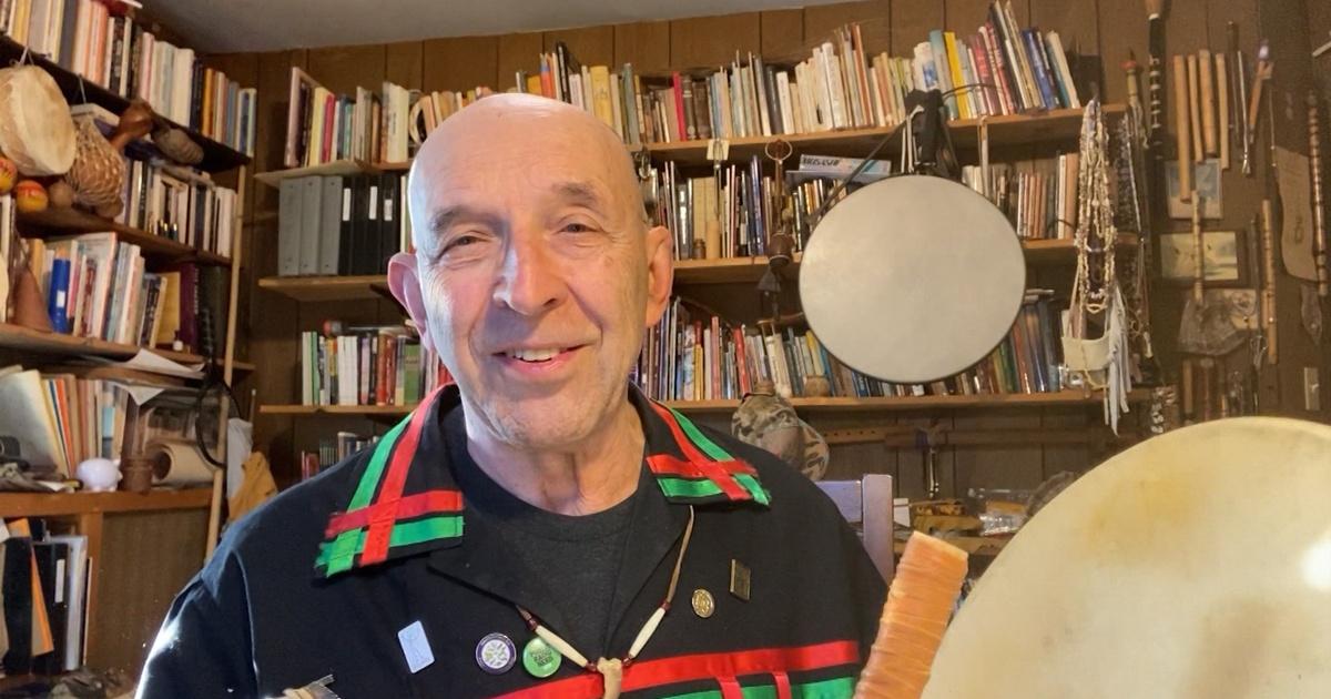 Joseph Bruchac sitting in front of a bookcase.