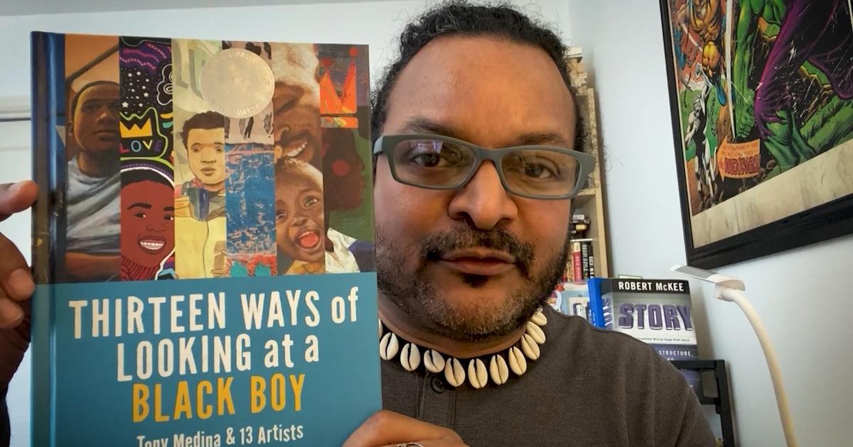 An image of Toni Medina holding a book.