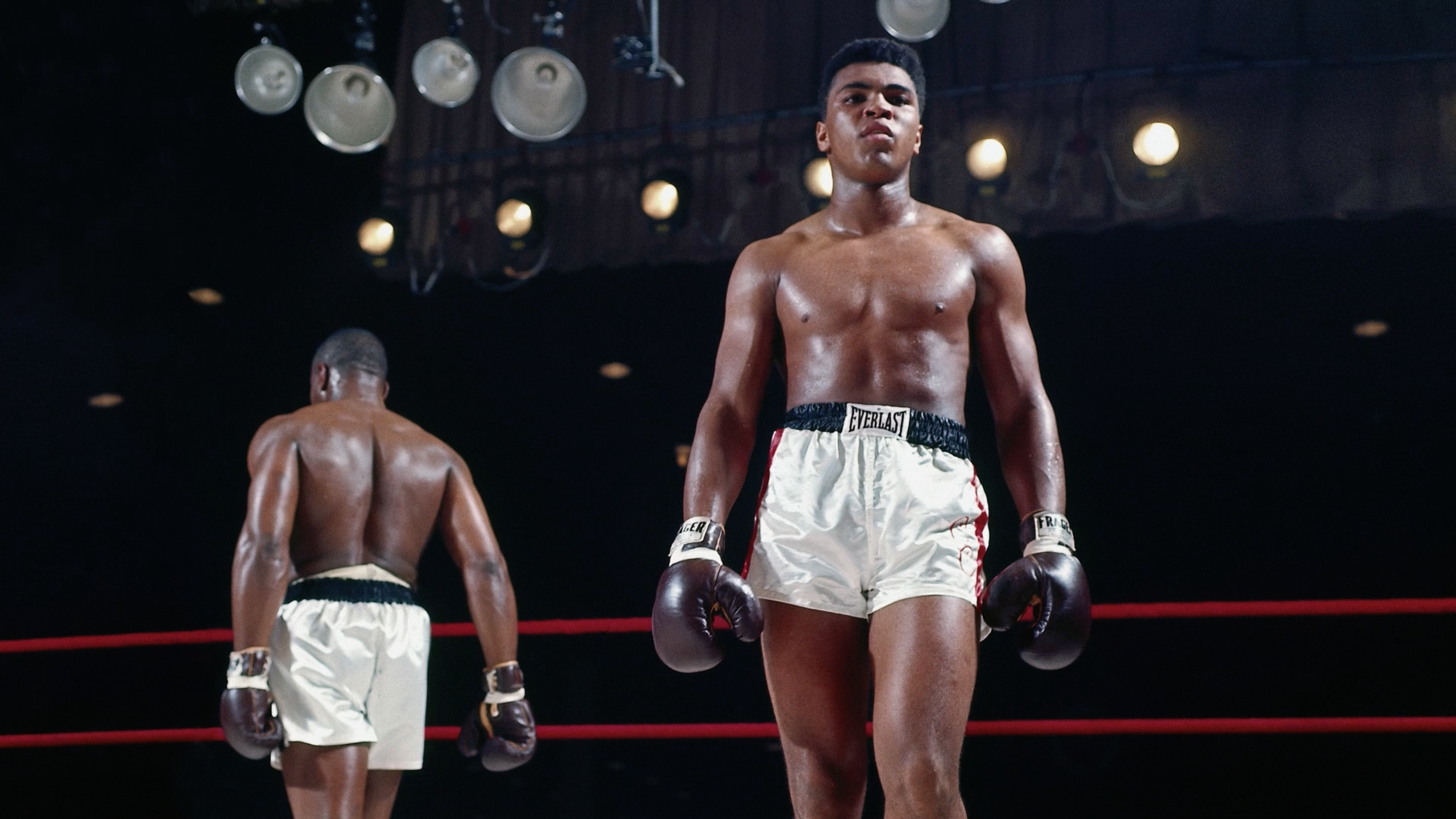 A photo of Muhammad Ali and another boxer in the background.
