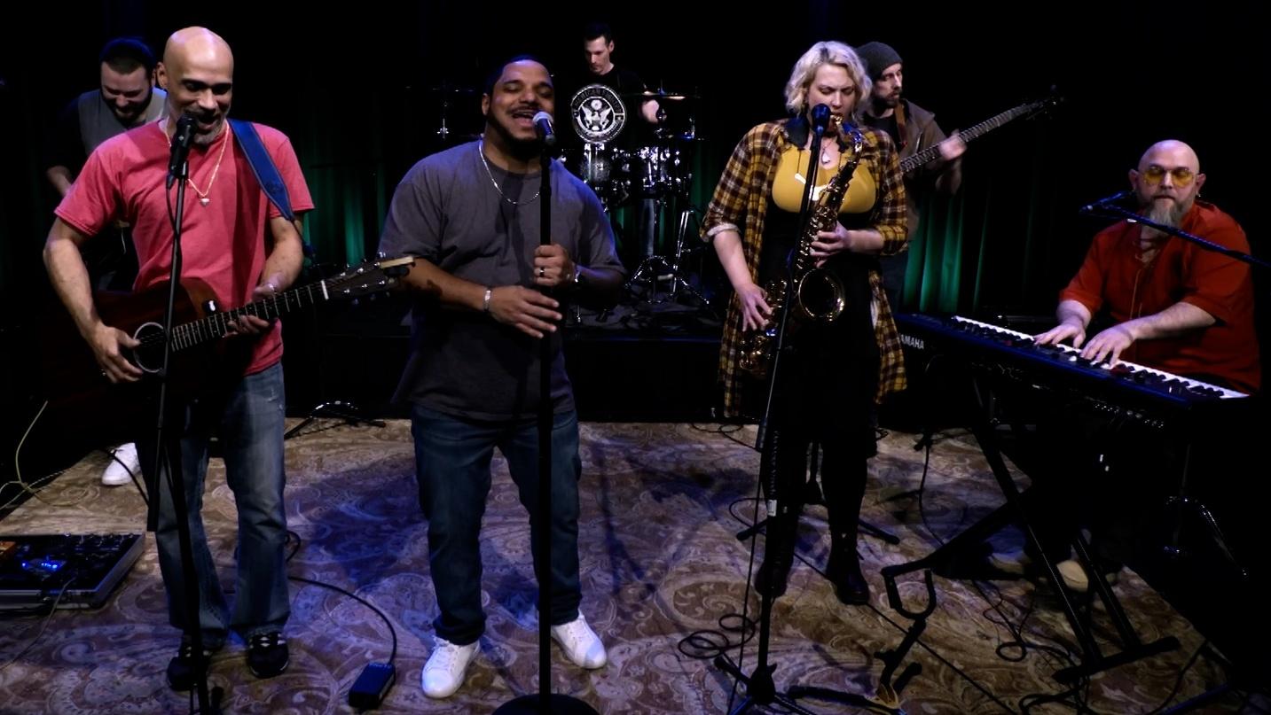 Group of musicians playing musical instruments and singing.