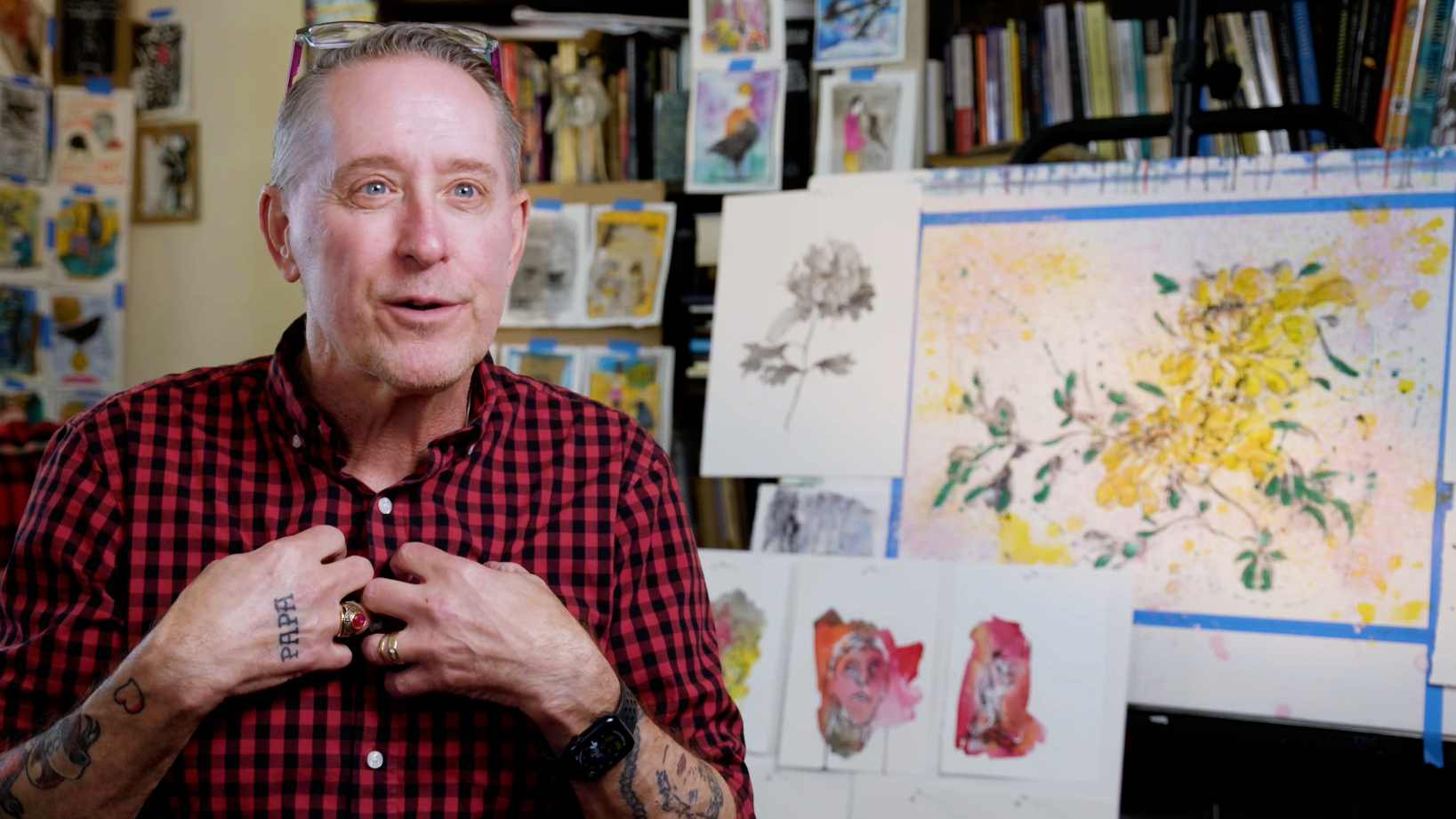 William Doan speaking in front of samples of his art.