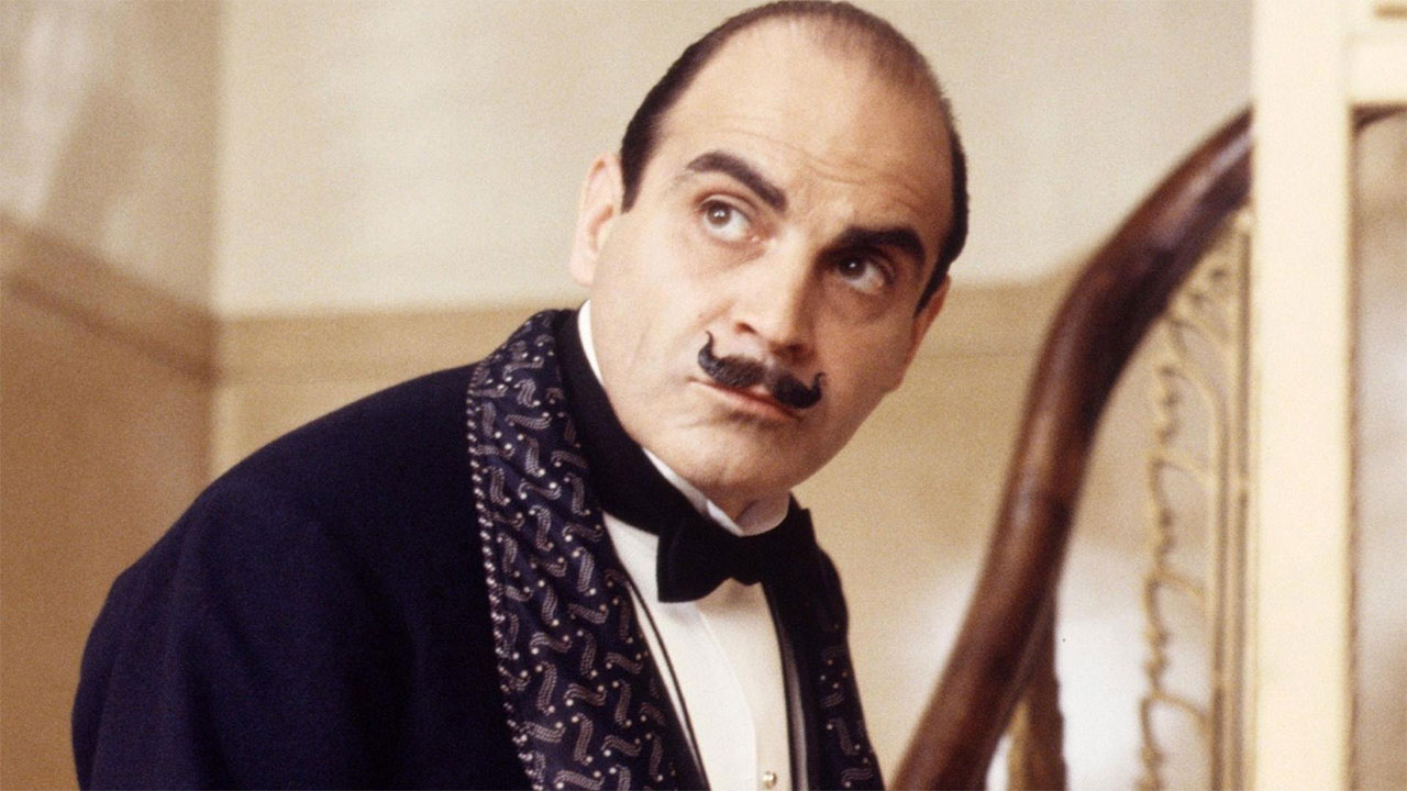 Older man with short curled black mustache in tuxedo.