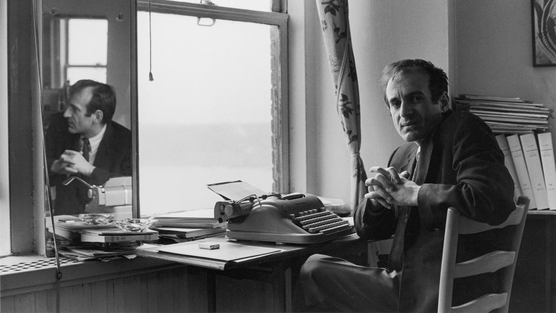 Elie Wiesel sitting at a desk with typewriter.