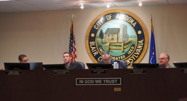 People sitting behind a desk large desk.