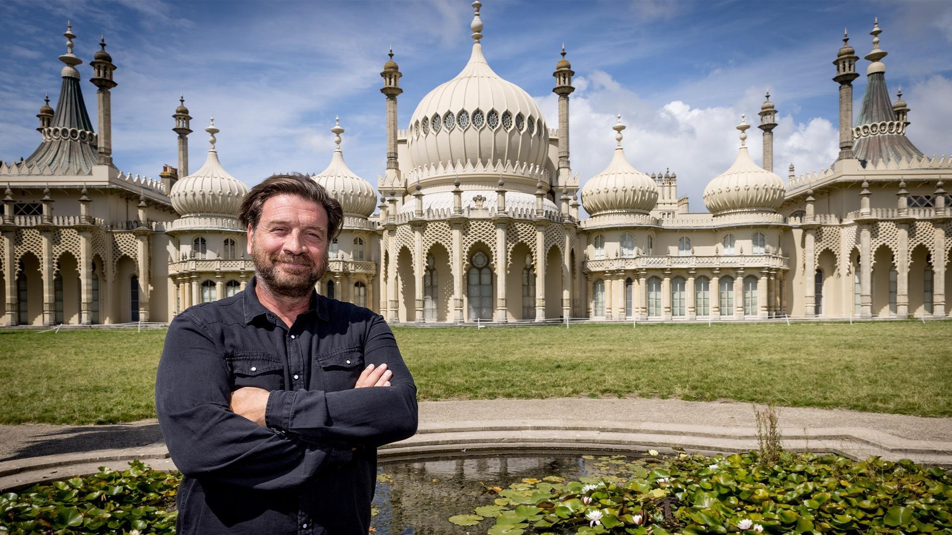 Nick Knowles standing in front of the spires of an old building.
